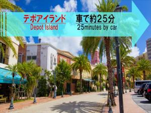 uma rua da cidade com palmeiras e edifícios em HOTEL 紅-bin- em Okinawa