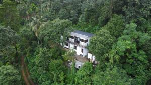 an aerial view of a house in the forest at The Meadows INN in Kottayam
