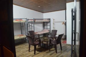 科特塔耶姆的住宿－The Meadows INN，客房设有四张双层床和一张桌子及椅子。