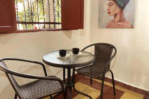 einen Tisch und zwei Stühle mit zwei Tassen drauf in der Unterkunft Apartaestudio Colonial, Aire Acondicionado, wifi 200 Mbps in Envigado