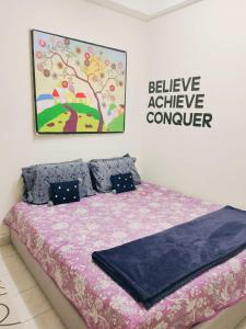 a bedroom with a bed with a sign that says believe achieve conquer at Dahlia Homestay Putrajaya in Putrajaya