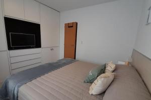 une chambre avec un grand lit avec une télévision à écran plat dans l'établissement Caleta View - Dpto Confortable, à Puerto Madryn