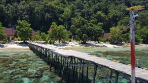 uma ponte de madeira sobre uma massa de água em Amoryg Resort and Dive Raja Ampat em Pulau Mansuar