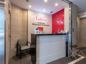 大阪市にあるTabist ユニホテル御堂筋本町の待合室には椅子があり、地下鉄のティキキ系列の看板がある