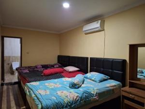 a bedroom with two beds and a air conditioner at villa romi in Puncak +16 photos