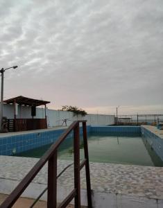 una piscina con una valla de madera al lado en Bamboleo Club Zorritos, en Zorritos