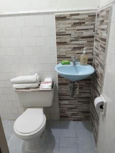 a bathroom with a toilet and a sink at Acogedor apartamento en Buga in Buga