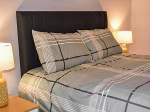 a bed with two pillows on it with two lamps at Harbour Apartment in Nairn