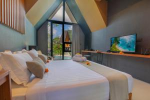 una camera da letto con un grande letto bianco con una grande finestra di Le Cielo Resort Umalas by Maviba a Canggu