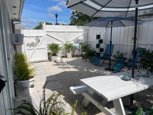 un patio con una mesa blanca y una sombrilla en White Rock Studio, en Jacksonville
