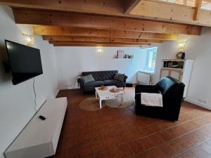 uma sala de estar com dois sofás e uma televisão em Comfortable cottage close to the beach, Portsall, 2 canoes em Ploudalmézeau