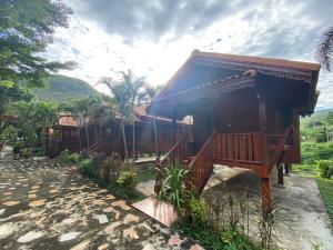 a small house with a blue roof and a patio at สวนดวงมณี รีสอร์ท in Ban Tha Thong Mon