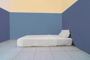 een bed in een kamer met een blauwe muur bij OYO 92893 Santana Residence Syariah in Bojongsalam