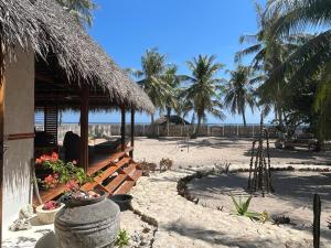 un resort sulla spiaggia con palme sullo sfondo di VILLA LANGIT TEDUH ROTE a Nembrala