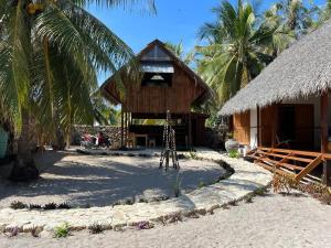 ein Gebäude am Strand mit einer Palme in der Unterkunft VILLA LANGIT TEDUH ROTE in Nembrala