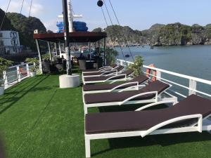 een rij ligstoelen op een boot in het water bij New Way Hotel in Cat Ba