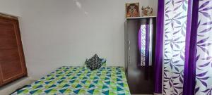 a bedroom with a bed with a green and blue at Vrinda homestay in Vrindāvan