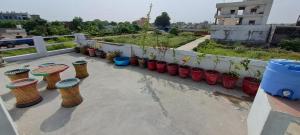 un ensemble de tabourets assis sur un patio avec des plantes dans l'établissement Vrinda homestay, à Vrindavan