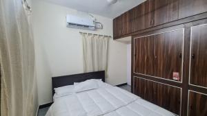 a bedroom with a bed and a wooden cabinet at Happy Home in Coimbatore