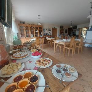 a table with many plates of food on it at Agritur Maso Spezial in Villa Lagarina