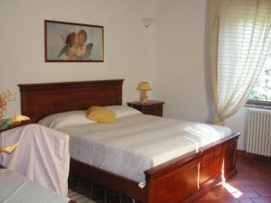 a bedroom with a bed and a picture on the wall at Casale Il Colombaio Di Toiano in Sovicille