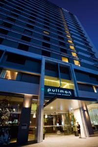 a building with a person standing in front of it at Pullman Sydney Olympic Park in Sydney