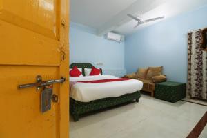 a bedroom with a bed and a couch in a room at OYO Flagship Sandhra Apartments in Pūvār