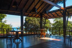 een terras met tafels en stoelen bij Japamala Resort by Samadhi - Adults Only in Tioman Island