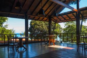 a patio with tables and chairs on a deck at Japamala Resort by Samadhi Age 12 and Above Only in Tioman Island