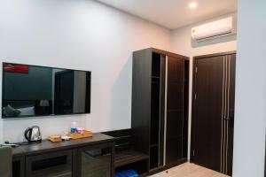 Cette chambre comprend un bureau, une télévision et une armoire. dans l'établissement Anna Hotel Binh Duong, à Bến Cát