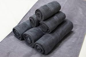 four rolls of grey towels stacked on a table at Tsukimura Building in Tokyo