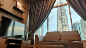 uma sala de estar com um sofá e uma grande janela em Sky Suites KLCC Homestay by BIRDY STAY em Kuala Lumpur
