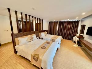 a bedroom with two beds and a flat screen tv at Romance hotel in Cat Ba