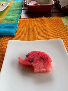 a piece of watermelon sitting on a white plate at The Views Kandy - 360 Mountain View in Kandy