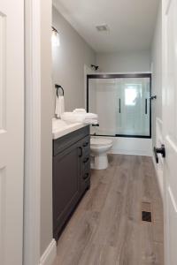 a white bathroom with a sink and a toilet at Main Street Balcony Apartment For up to 8 guests! in St. Charles