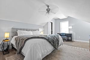 a white bedroom with a bed and a ceiling fan at Main Street Balcony Apartment For up to 8 guests! in St. Charles