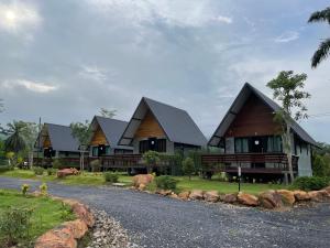 eine Reihe von Häusern am Straßenrand in der Unterkunft Baanrimfai Homestay in Ban Thung Sang