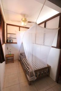 a room with a bed with a net in it at Seabreeze Hostel Bali in Canggu