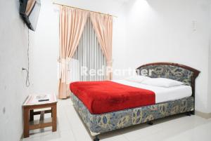 1 dormitorio con cama, ventana y mesa en Hotel Borobudur Kemayoran Syariah Mitra RedDoorz, en Yakarta