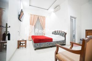 1 dormitorio con cama, ventana y silla en Hotel Borobudur Kemayoran Syariah Mitra RedDoorz, en Yakarta