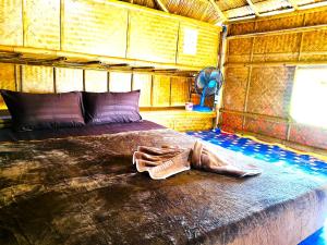 a bedroom with a bed with a pair of shoes on it at Asama Bungalow in Ko Lanta