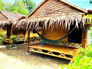 a hut with a hammock in front of it at Asama Bungalow in Ko Lanta