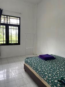 um quarto branco com uma cama e uma janela em Sejahtera Homestay em Cangkringan