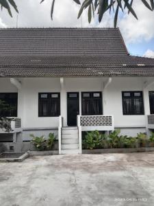 uma casa branca com um telhado preto em Sejahtera Homestay em Cangkringan