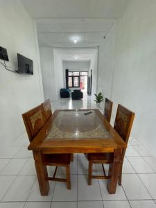 uma sala de jantar com uma mesa de madeira e cadeiras em Sejahtera Homestay em Cangkringan