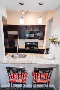 una cocina con 2 sillas rojas y un fregadero en Convenient 2 bedroom 1 bathroom en St. Louis