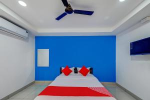 a bedroom with a bed with a blue wall at SPOT ON Hotel Utrishree in Khandagiri