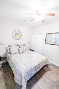 a white bedroom with a bed and a ceiling fan at Convenient 2 bedroom 1 bathroom in Saint Louis