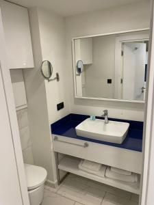 a bathroom with a sink and a mirror and a toilet at Seaview-Studio Apartments in Orbi City in Batumi
