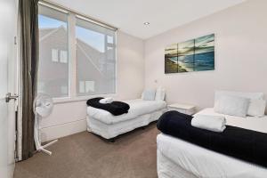 a living room with two beds and a window at Taupo Penthouse in Taupo